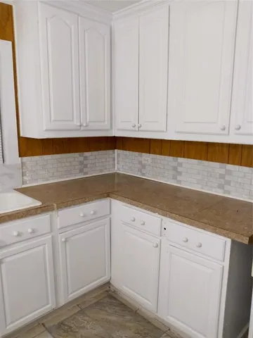 a kitchen with white cabinets and white appliances