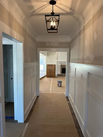 a room with a fireplace and chandelier