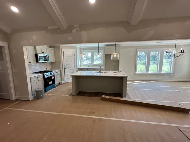 a kitchen that has a lot of cabinets and stainless steel appliances