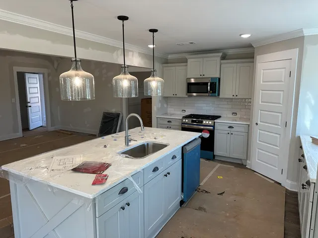 a view of an empty room with window and chandelier fan