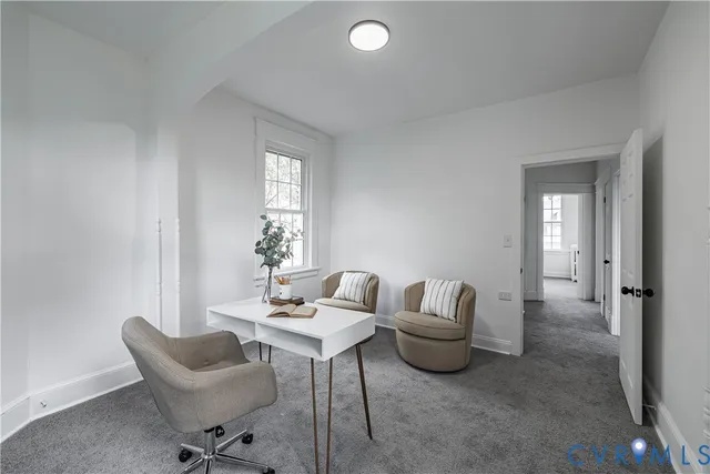 a view of a hallway with workspace and a window