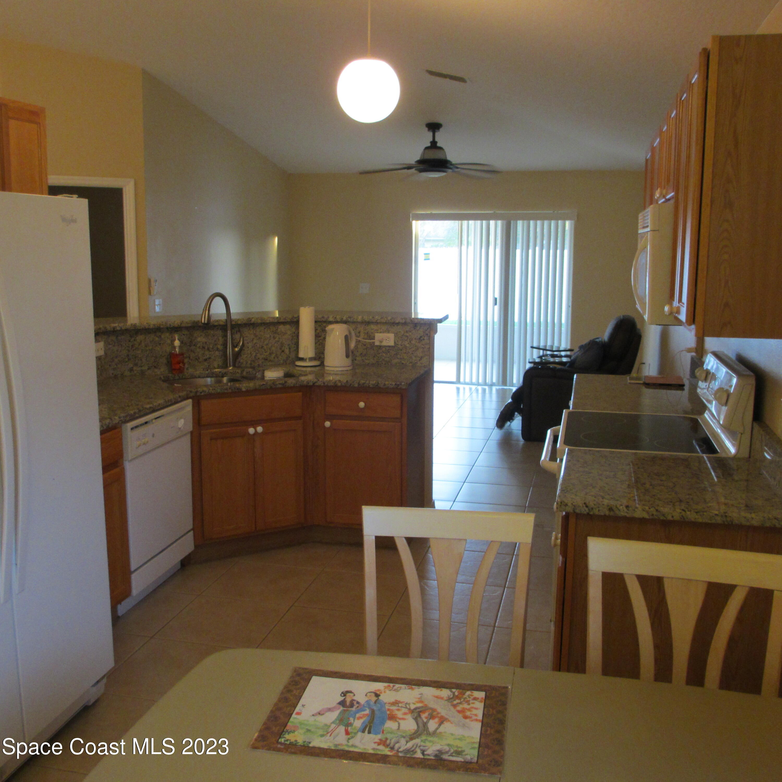 1925 Canopy Drive Melbourne, FL 32935 - Photo 6 of 17 a kitchen with stainless steel appliances granite countertop a sink a stove a refrigerator a washer dryer and white cabinets