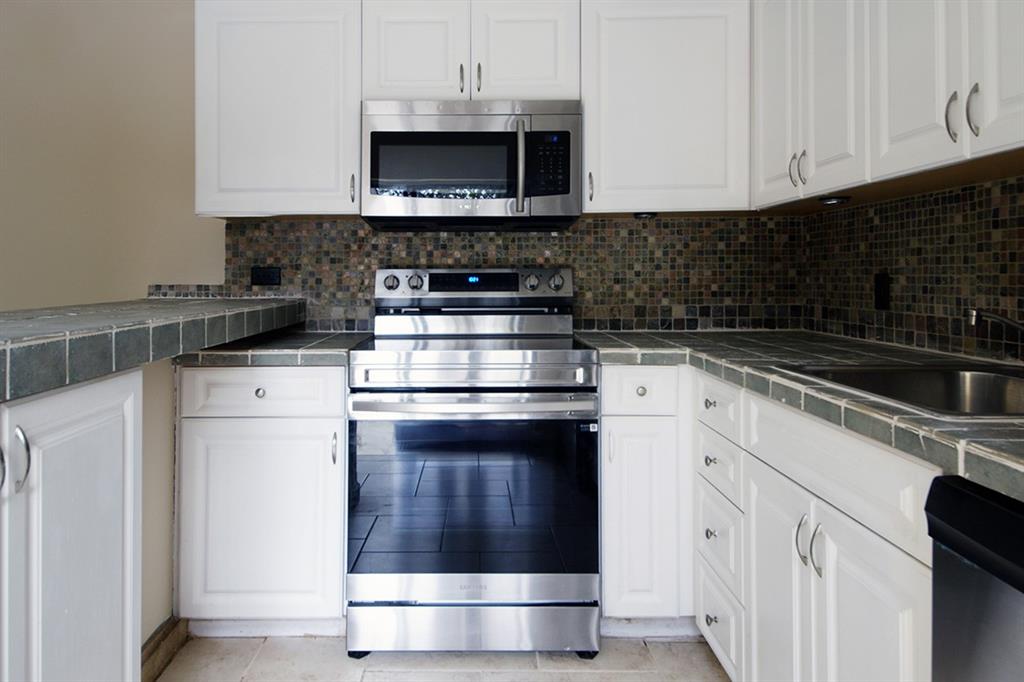 1700 Embassy Drive, Unit 402 West Palm Beach, FL 33401 - Photo 14 of 38 a kitchen with appliances a sink and cabinets