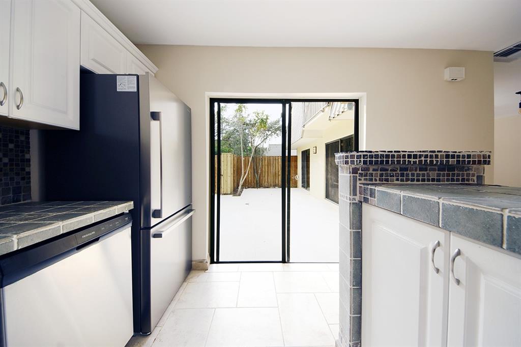 1700 Embassy Drive, Unit 402 West Palm Beach, FL 33401 - Photo 16 of 38 a kitchen with a refrigerator and a stove