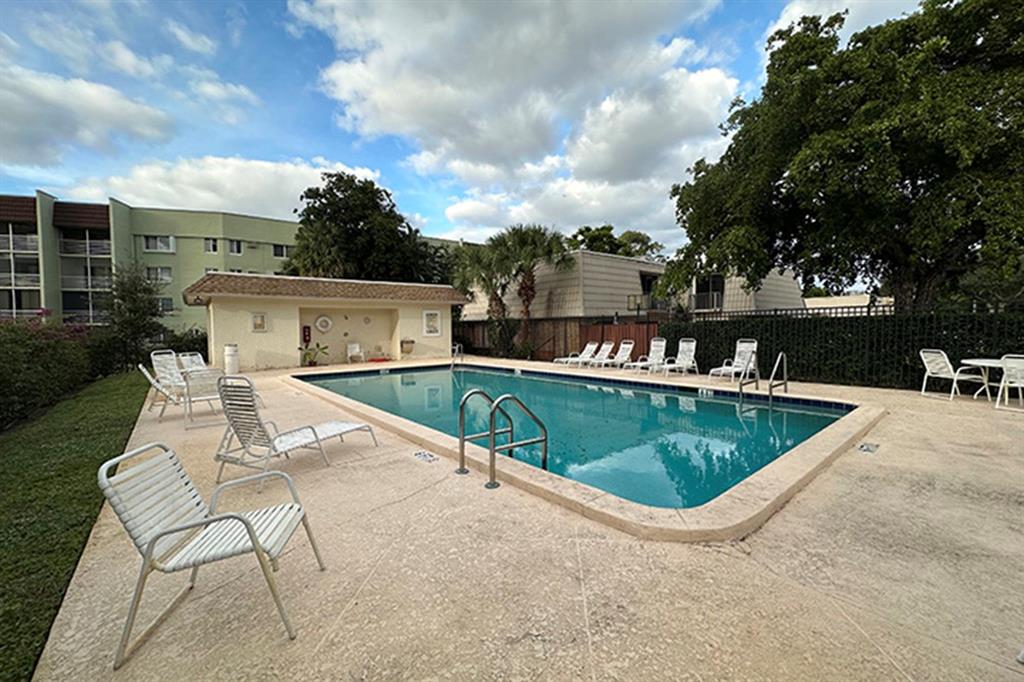 1700 Embassy Drive, Unit 402 West Palm Beach, FL 33401 - Photo 36 of 38 a view of a swimming pool with outdoor seating