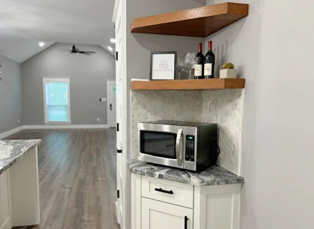 a kitchen with granite countertop a stove microwave and sink