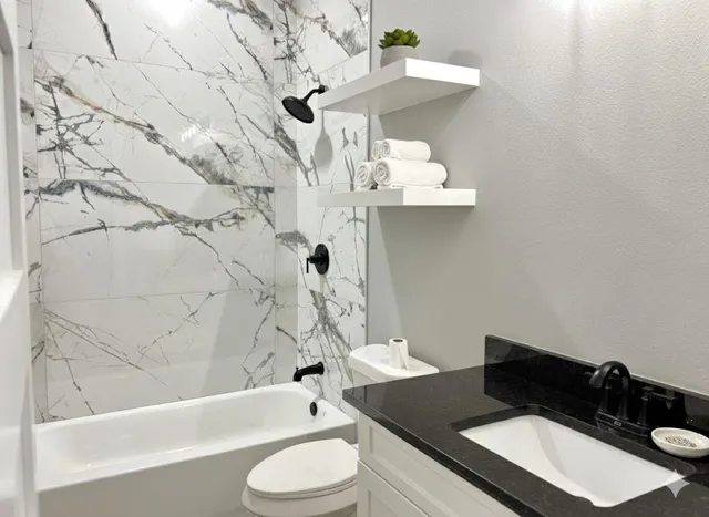 a bathroom with a granite countertop sink and a mirror