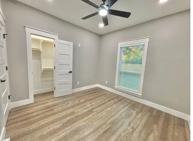 an empty room with closet and fan