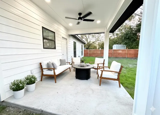 a living room with patio furniture and a potted plant