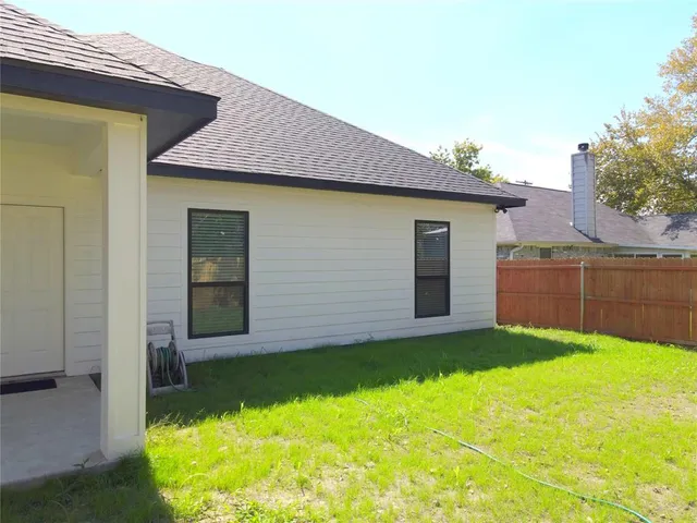 a view of an house with backyard space and balcony
