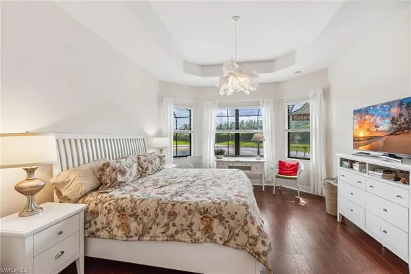 a spacious bedroom with a bed and wooden floor