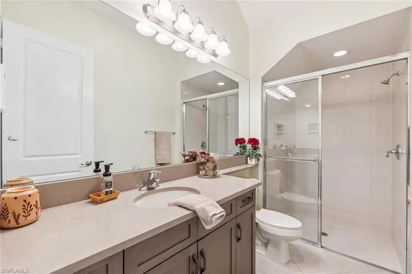 a bathroom with a granite countertop sink a toilet and a mirror
