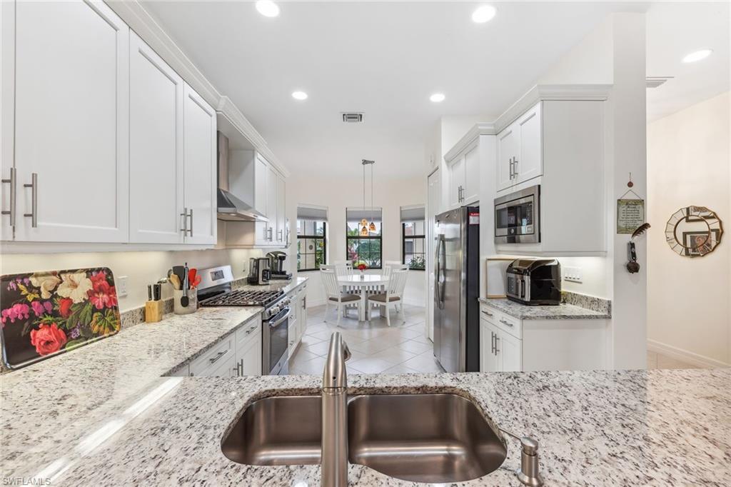 4360 Aurora Street Naples, FL 34119 - Photo 4 of 49 Kitchen features stainless steel appliances, vented hood.