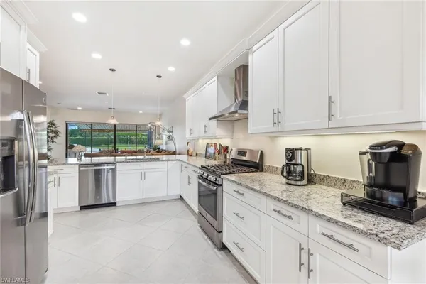 a kitchen with stainless steel appliances granite countertop a stove sink and cabinets