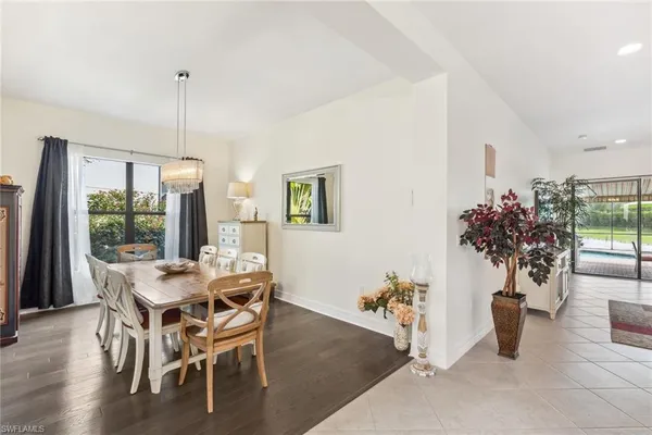 a dining room with furniture potted plants and wooden floor