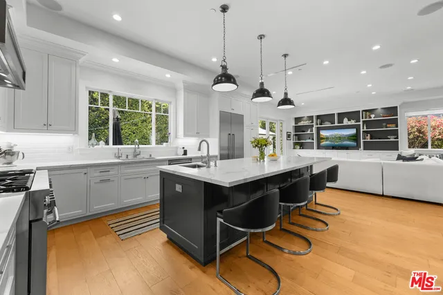 a kitchen with a sink appliances and windows