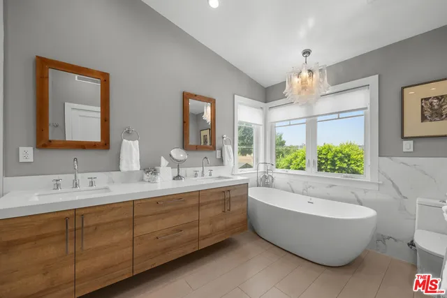 a bathroom with a tub sink shower and mirror