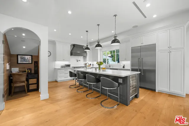 a kitchen with stainless steel appliances granite countertop a sink a stove and a refrigerator