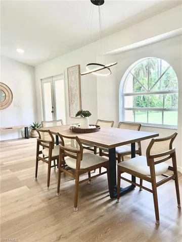a dining room with furniture a chandelier and wooden floor