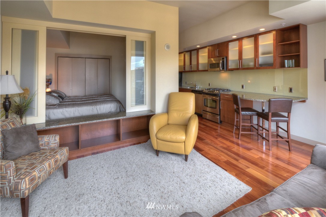 900 Lenora Street, Unit W1105 Seattle, WA 98121 - Photo 9 of 25 a living room with furniture and a wooden floor
