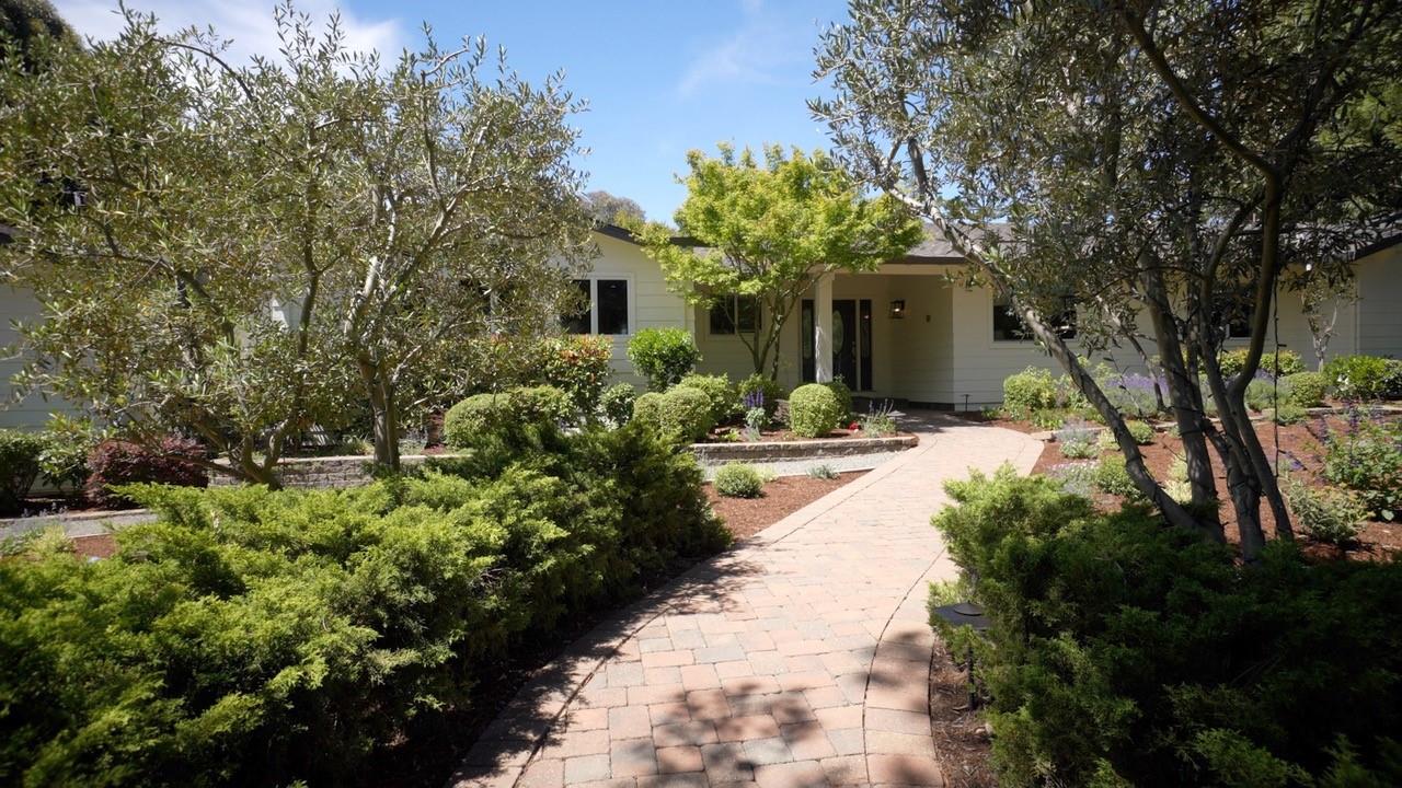 a view of a house with a yard and potted plants