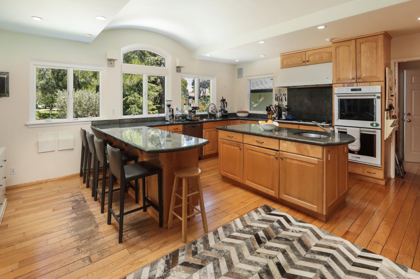 285 Ridgeway Road Woodside, CA 94062 - Photo 12 of 18 a kitchen with stainless steel appliances granite countertop a stove top oven a sink dishwasher a dining table and chairs with wooden floor