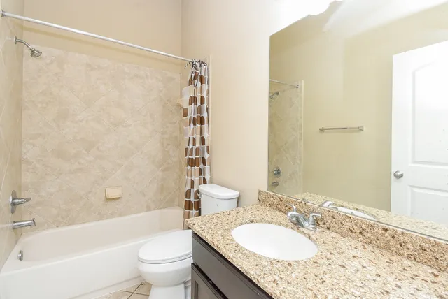 a bathroom with a granite countertop sink toilet and shower