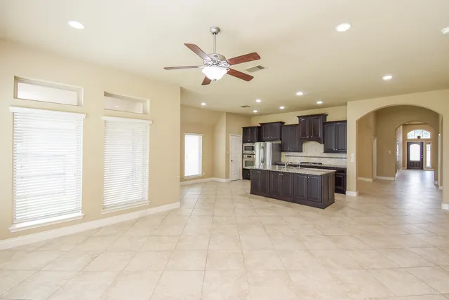 a view of kitchen with kitchen island stainless steel appliances sink cabinets and window