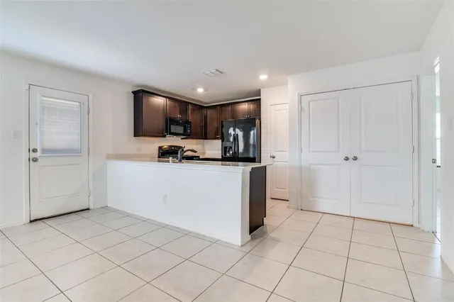 a kitchen with stainless steel appliances a refrigerator sink and microwave