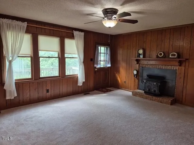 a view of an empty room with a fireplace and a window