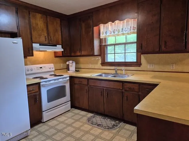 a kitchen with a sink stove top oven and cabinets