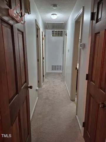 a view of hallway with stainless steel appliances wooden floor