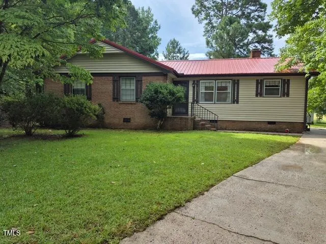 a view of a house with a yard and sitting area