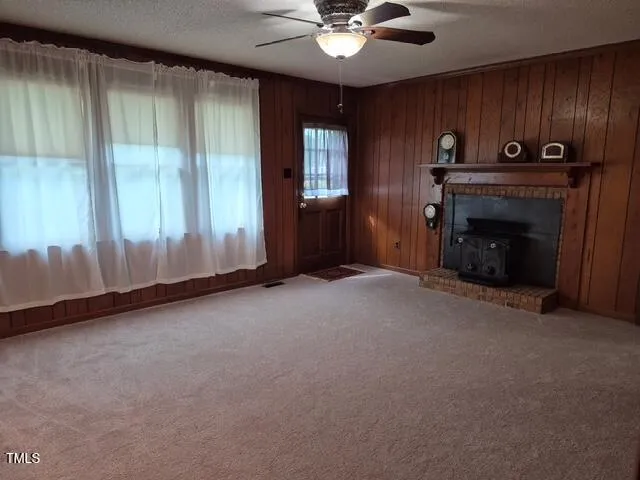 an empty room with windows cabinet and fireplace