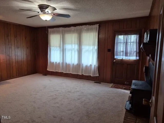 an empty room with windows and fan