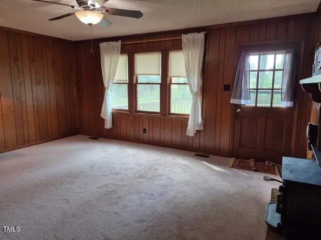 an empty room with windows and fan
