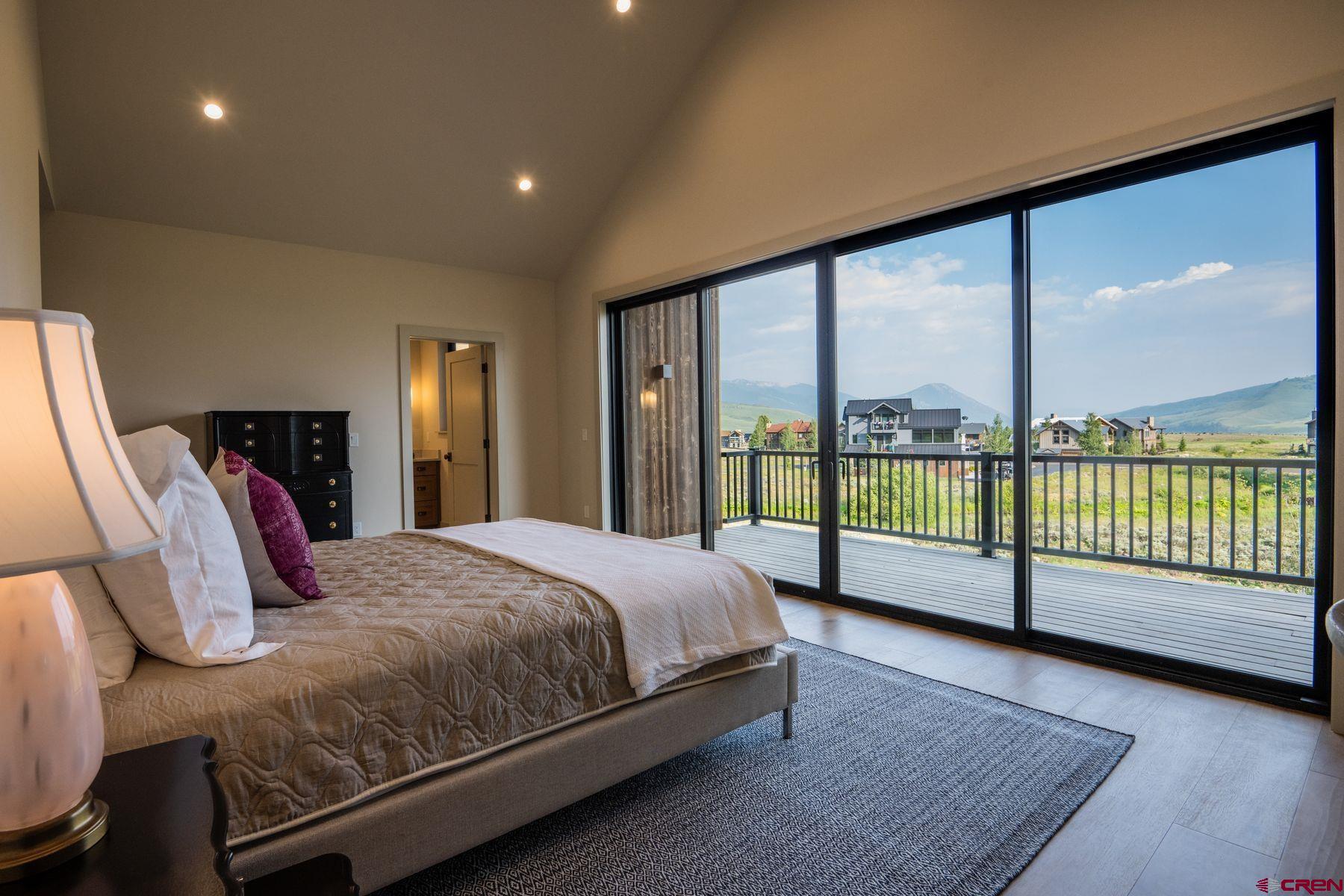 180 Elk Valley Road, Unit 109 Crested Butte, CO 81224 - Photo 14 of 36 a bed sitting in a bedroom next to a large window