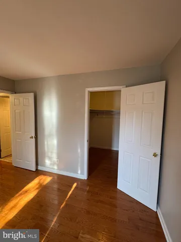 an empty room with wooden floor and closet area