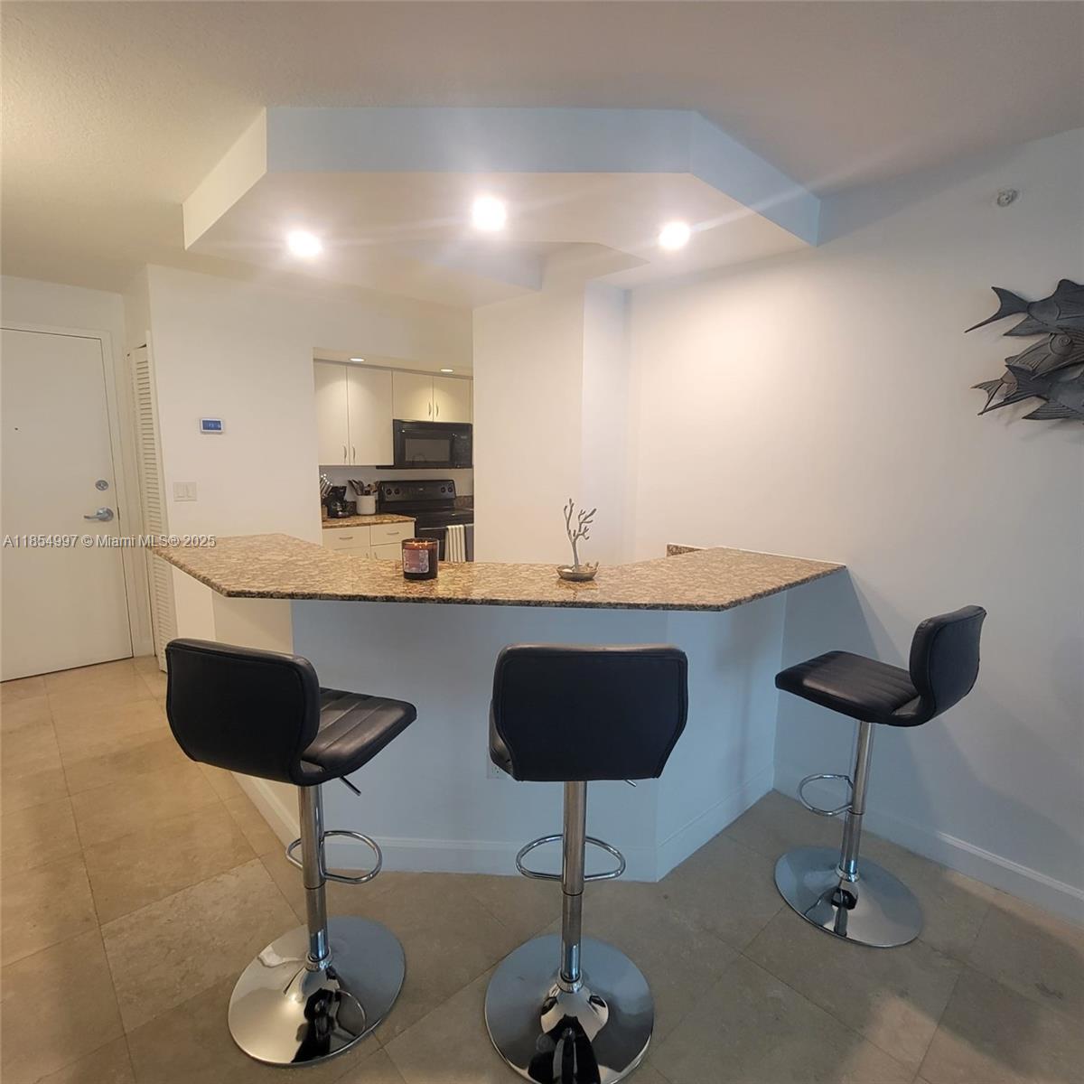 6917 Collins Avenue, Unit 408 Miami Beach, FL 33141 - Photo 14 of 39 a kitchen with granite countertop a counter space a sink and cabinets