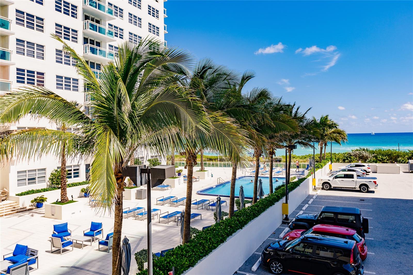 6917 Collins Avenue, Unit 408 Miami Beach, FL 33141 - Photo 22 of 39 a view of a swimming pool with a table and chairs