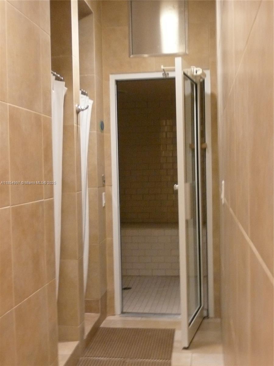 6917 Collins Avenue, Unit 408 Miami Beach, FL 33141 - Photo 28 of 39 a bathroom with a shower and a glass door