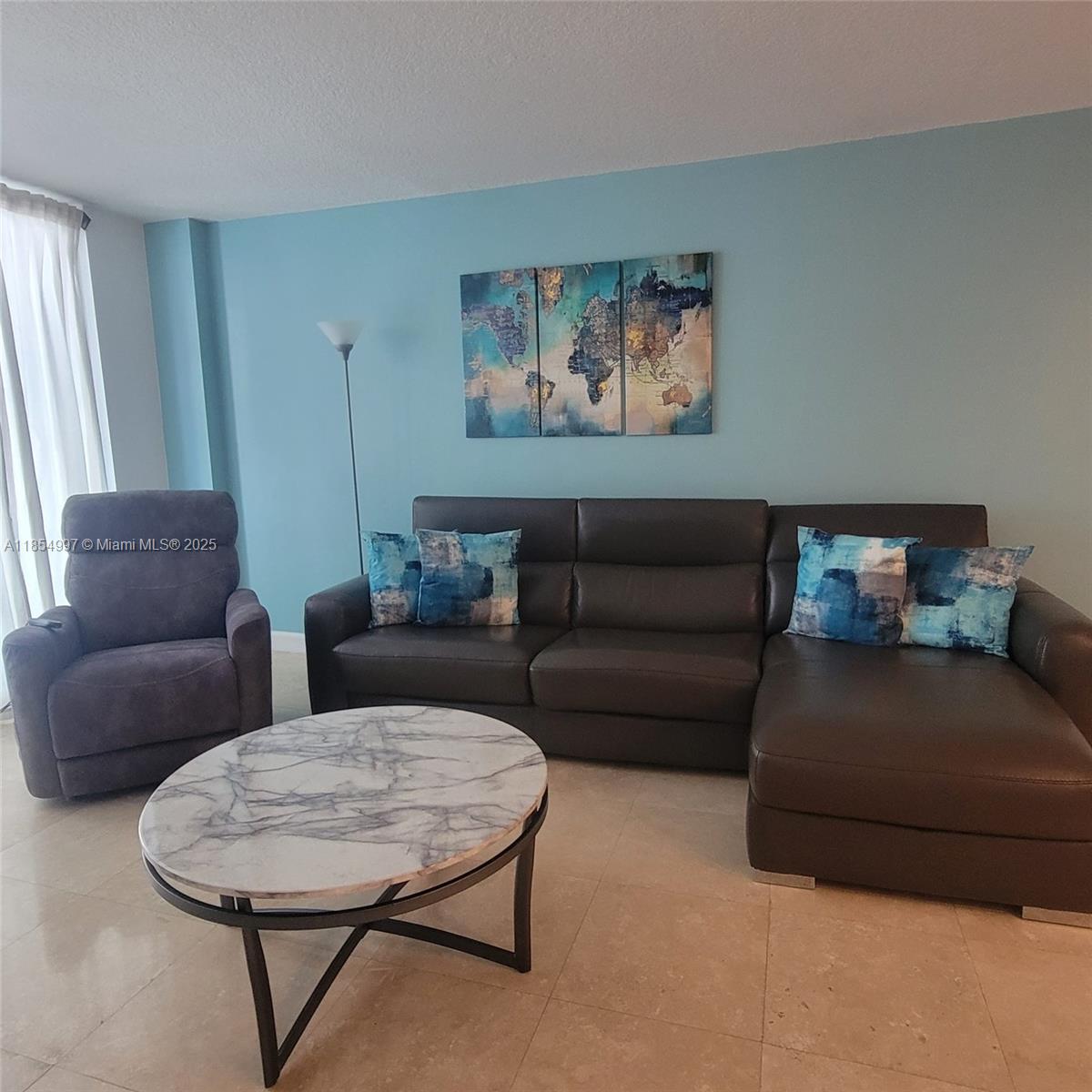 6917 Collins Avenue, Unit 408 Miami Beach, FL 33141 - Photo 3 of 39 a living room with furniture a couch a window and a potted plant on table