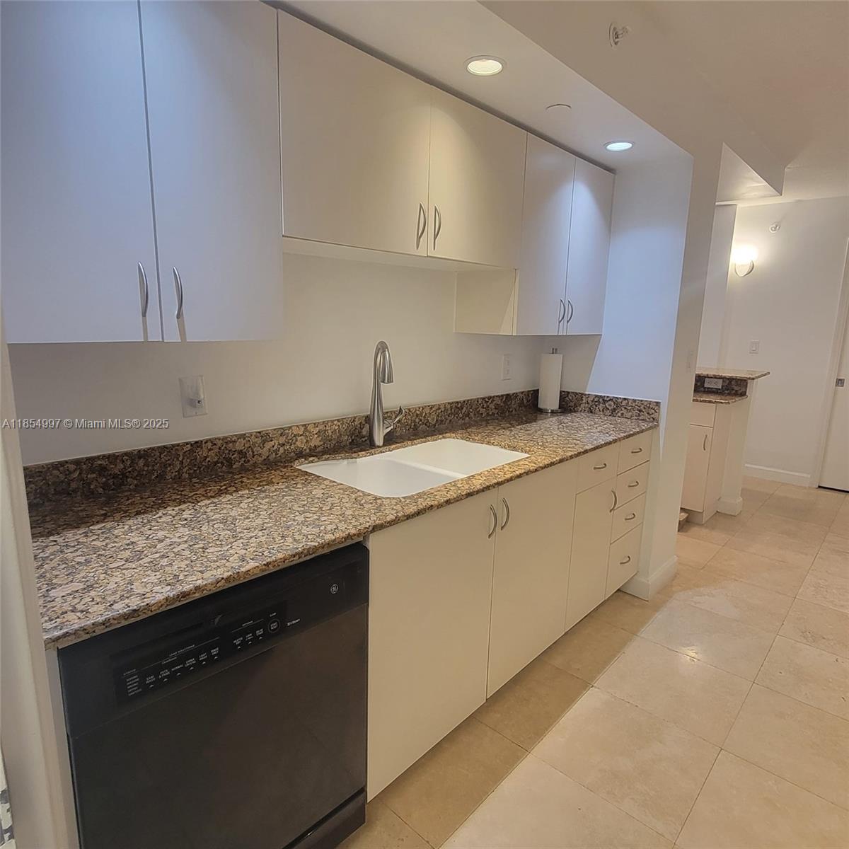 6917 Collins Avenue, Unit 408 Miami Beach, FL 33141 - Photo 6 of 39 a kitchen with a sink stove and cabinets