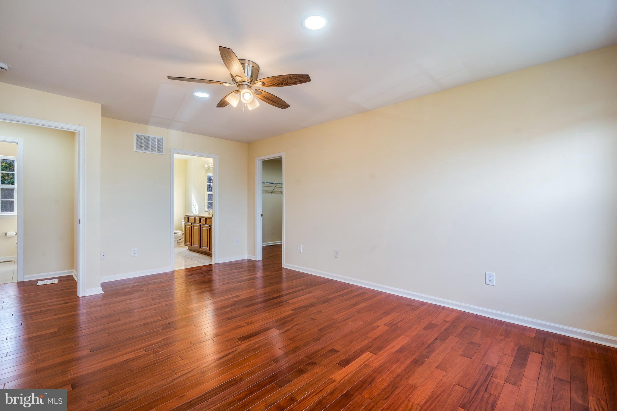 23 Homestead Drive Pemberton, NJ 08068 - Photo 32 of 40 a view of an empty room with wooden floor and a ceiling fan