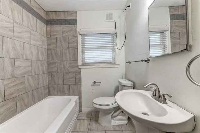 a bathroom with a sink a toilet and bathtub
