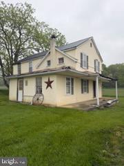 13804 Mercersburg Road Clear Spring, MD 21722 - Photo 41 of 48 a view of a white house that has a small yard and trees