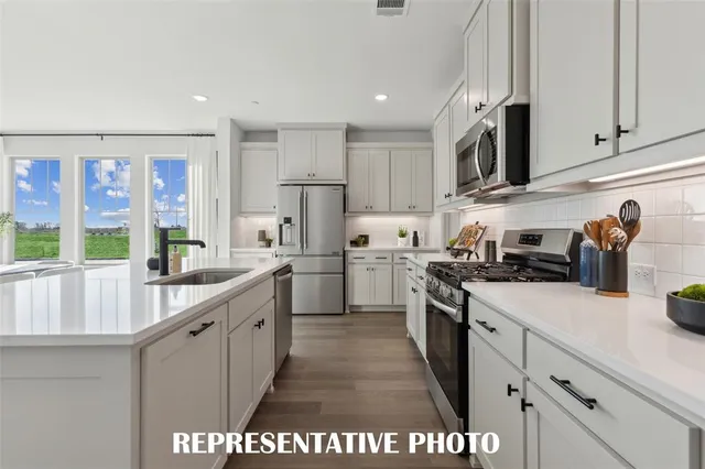 a kitchen with stainless steel appliances granite countertop a sink and cabinets