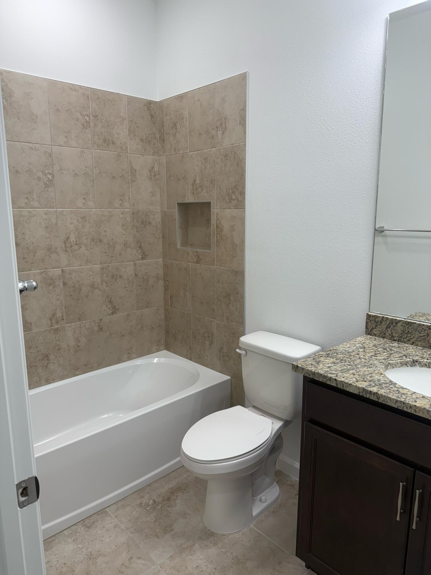 Undisclosed Address Loxahatchee, FL 33470 - Photo 12 of 17 a bathroom with a granite countertop toilet a sink and bathtub