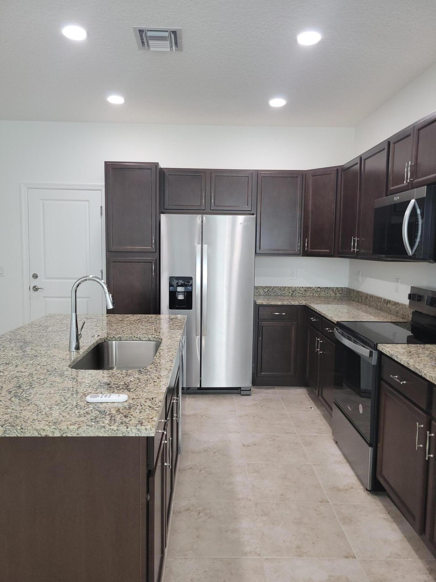 Undisclosed Address Loxahatchee, FL 33470 - Photo 3 of 17 a kitchen with stainless steel appliances granite countertop a sink stove and refrigerator