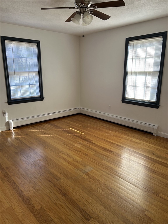 10 Walter Street Norton, MA 02766 - Photo 28 of 33 an empty room with wooden floor chandelier fan and windows